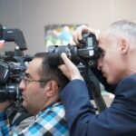 Jak słowackie media kształtują opinie społeczne o Polsce, UE i świecie Fotoreporterzy relacjonujący wydarzenie w pomieszczeniu, z profesjonalnym sprzęt