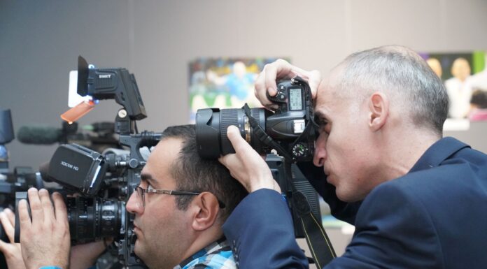 Jak słowackie media kształtują opinie społeczne o Polsce, UE i świecie Fotoreporterzy relacjonujący wydarzenie w pomieszczeniu, z profesjonalnym sprzęt
