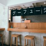 Nowoczesne wnętrze małej restauracji z drewnianym barem i stołkami