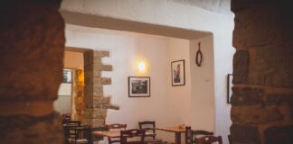 Przytulne wnętrze małej restauracji z drewnianymi stołami i rustykalnym wystroje