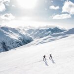 Dwóch narciarzy wspina się po ośnieżonym stoku w Ischgl w Austrii